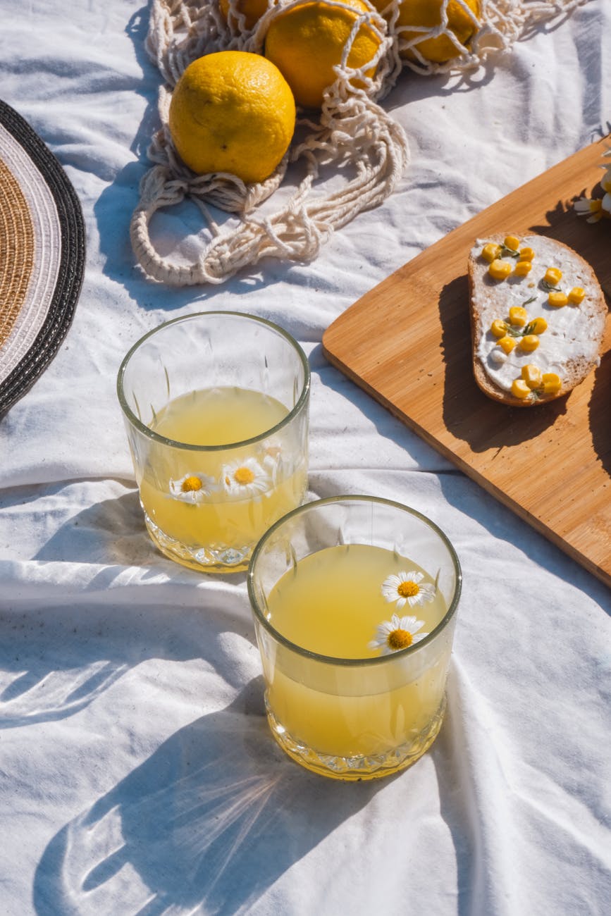 drinks and food standing on a blanket in sunlight